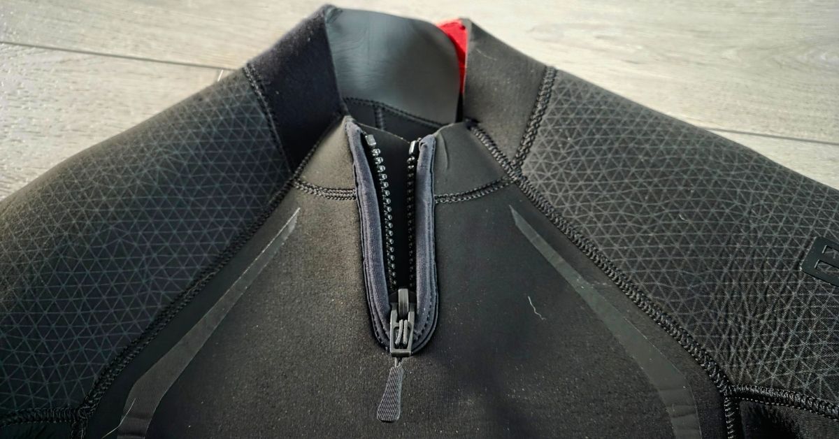 Close up of neck zipper of BARE Reactive 5mm wetsuit showing wear from dozens of uses. For article titled BARE Reactive 5mm Wetsuit Review.