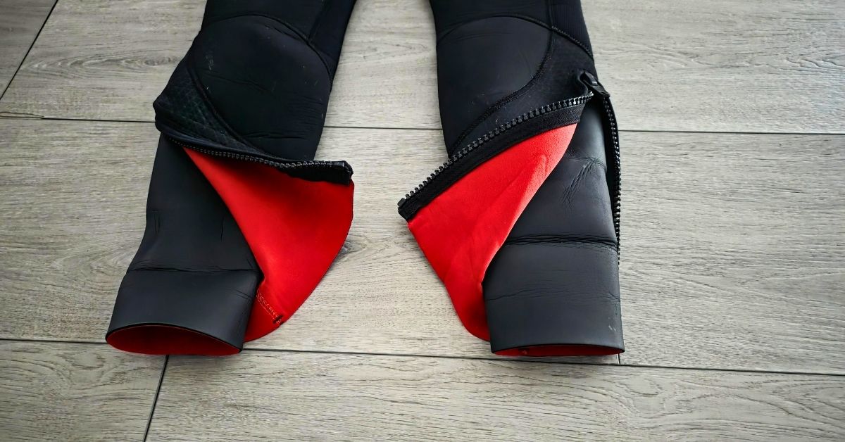 Close up of ankle zippers of BARE Reactive 5mm wetsuit showing wear from dozens of uses. For article titled BARE Reactive 5mm Wetsuit Review.