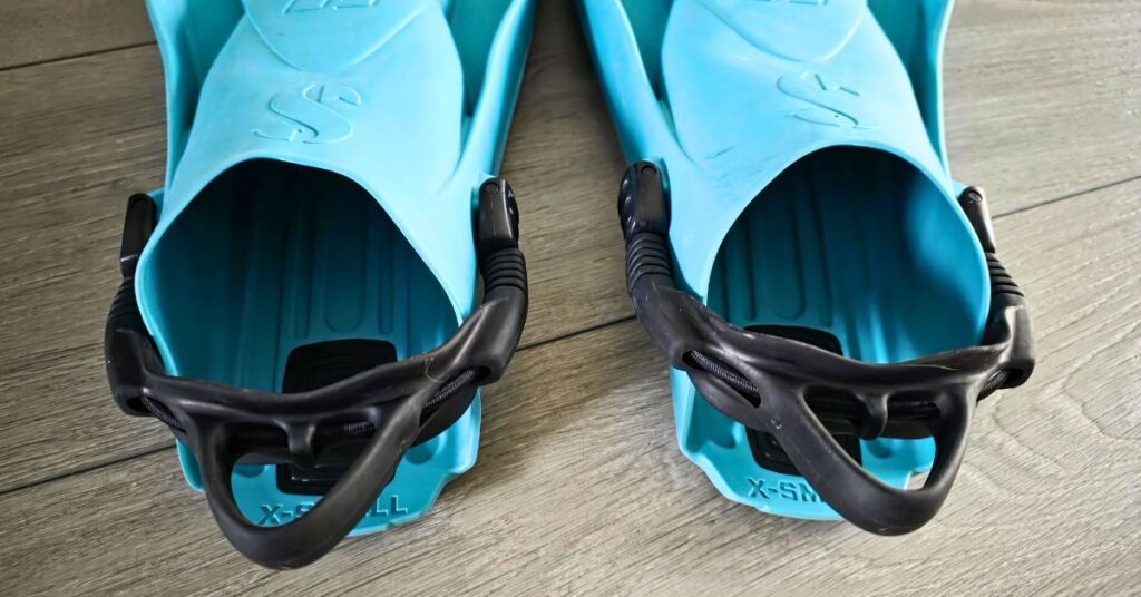Close up of the foot pocket and straps of SCUBAPRO GO Sport fins side by side with visible wear from years of use. For article titled SCUBAPRO GO Sport Review